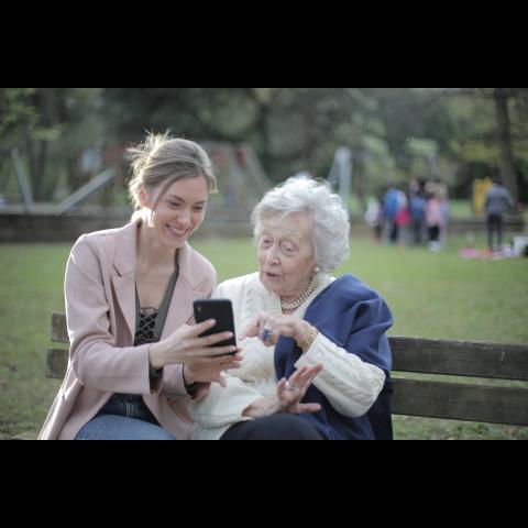 femme aidant une personne âgée avec un natel